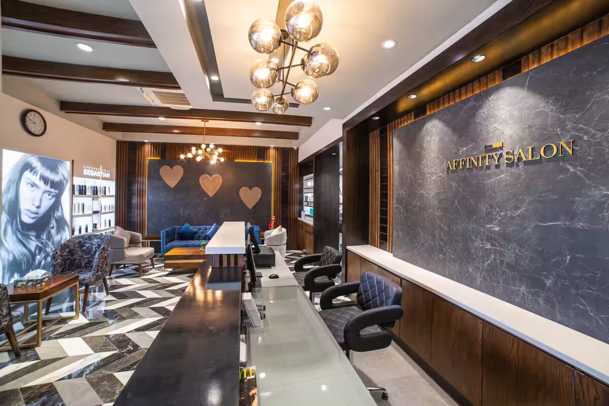 Reception desk beside the marble Affinity Salon wall, with the lounge behind